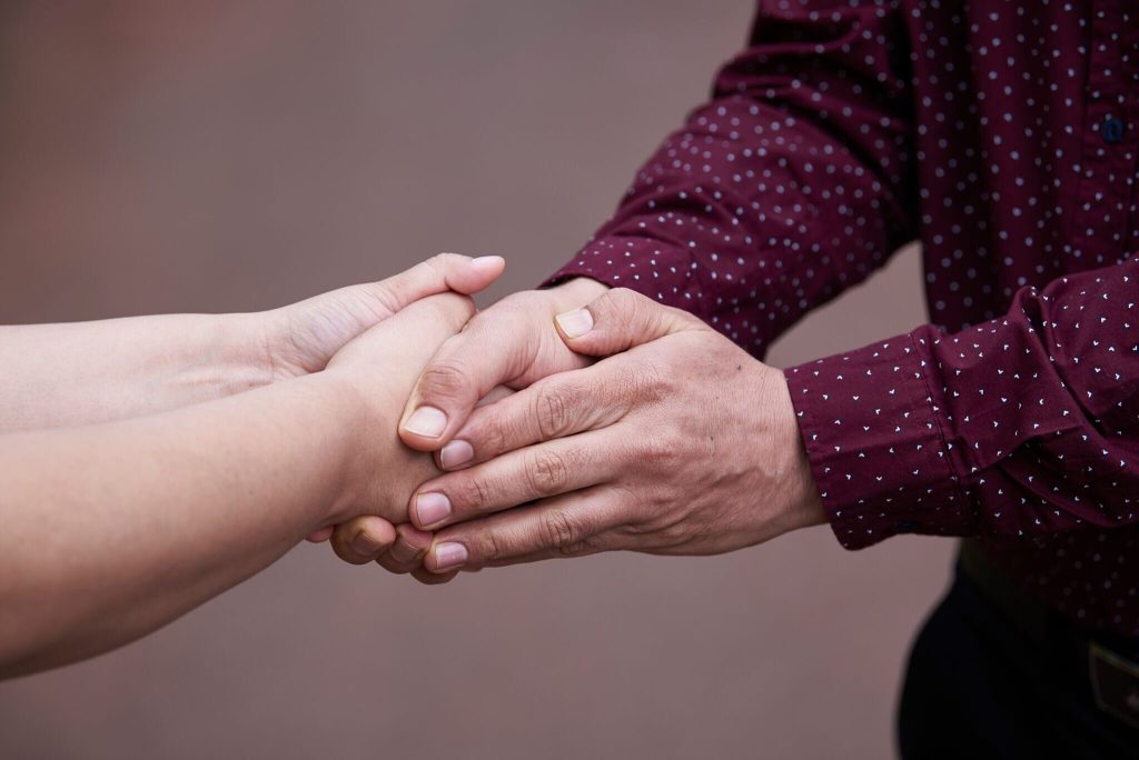 2 people holding hands together in close-up