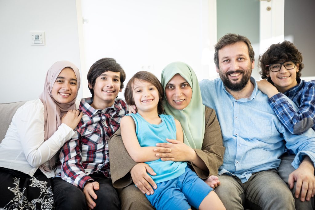 Big multicultural family sitting in couch