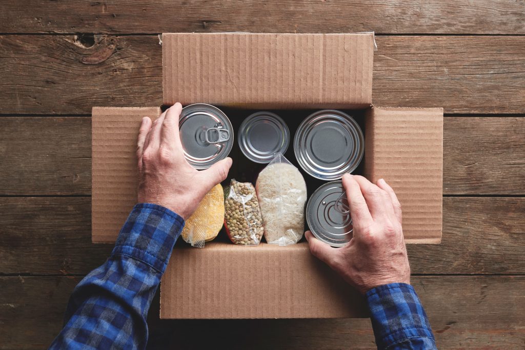 Hands of volunteer packing food for donations