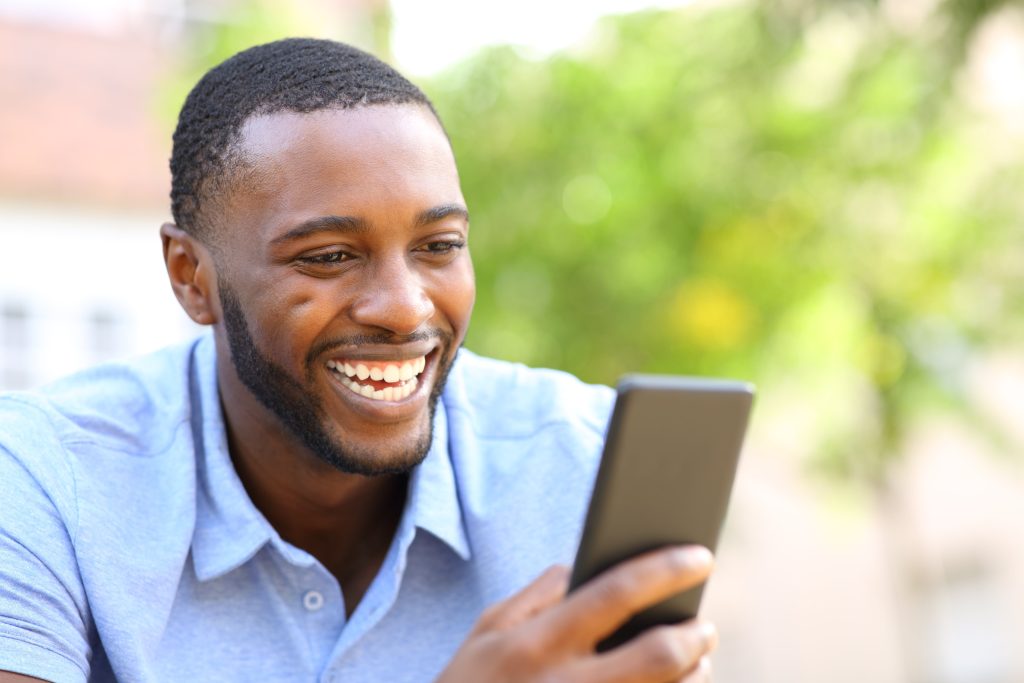 Black men laughing while looking at cellphone