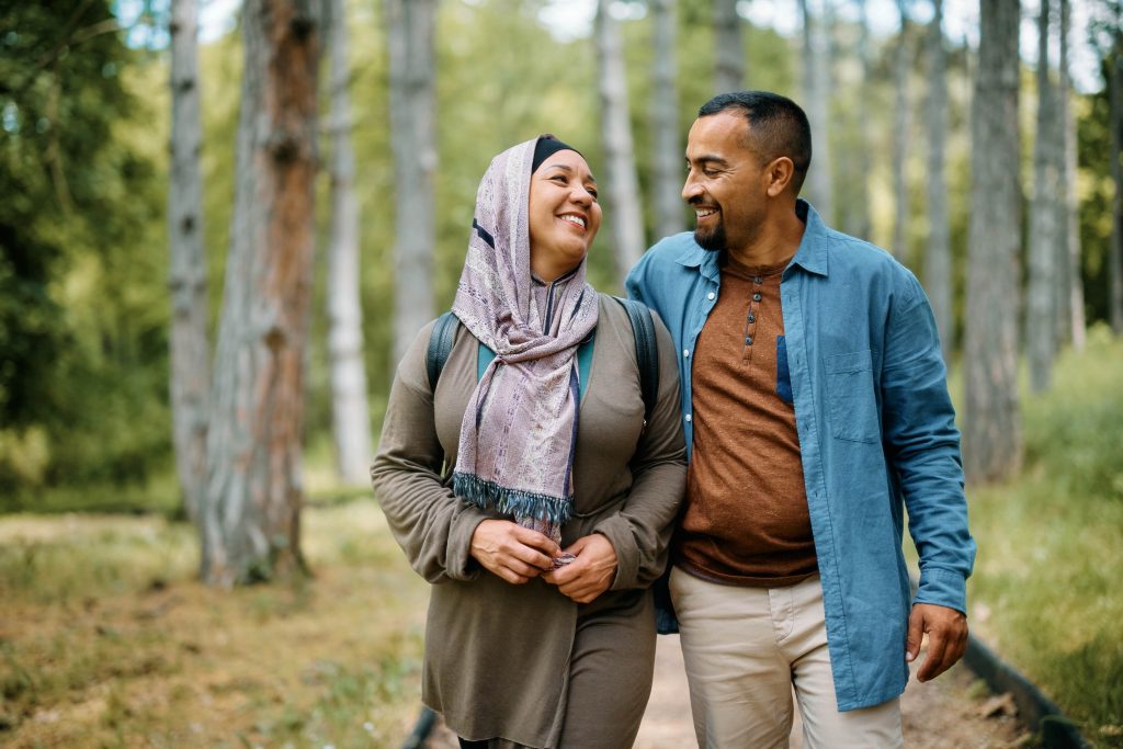 Couple walking together on the forest while looking at each other