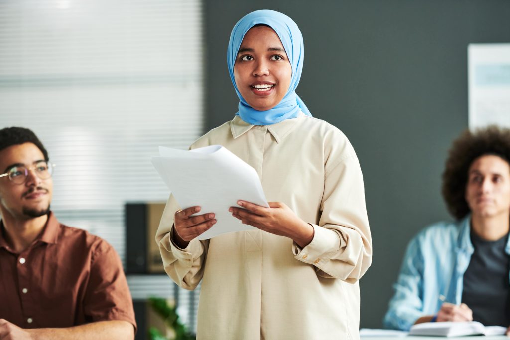 Multicultural young woman gives speech to colleagues