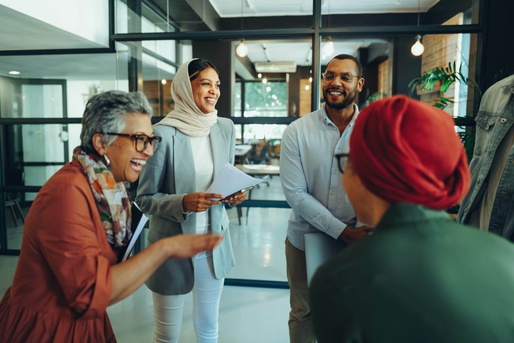 Multicultural group laughing in an office setting