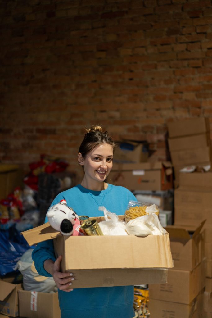 Woman holding box with donation items